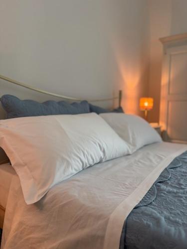 a bed with a white pillow and a lamp at IL CARRUBO La dimora in Monopoli