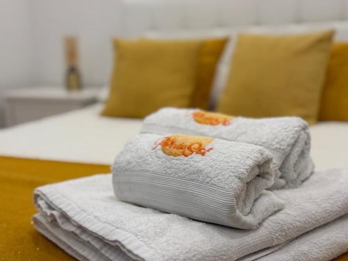 a pile of towels sitting on top of a bed at Sunset House over the Sea in Sesimbra