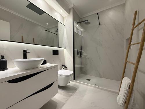 a bathroom with a sink and a toilet and a shower at Sunset House over the Sea in Sesimbra