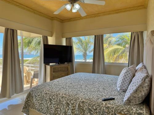 a bedroom with a bed and a large window at Beautiful beachfront space and pool in Mazatlán