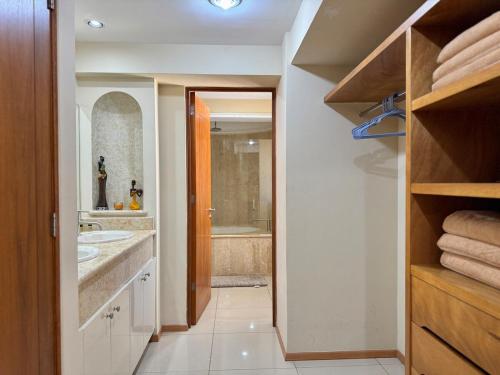 a bathroom with a sink and a bath tub at Beautiful beachfront space and pool in Mazatlán