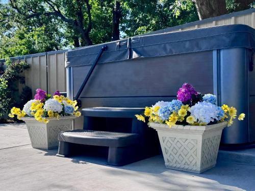 a bench and two potted flowers next to a bench and a piano at THE CW HOUSE in Claude