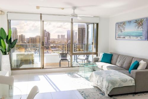 a living room with a couch and a glass table at Top of The Mark - Top Floor Apartment, Free Parking in Gold Coast