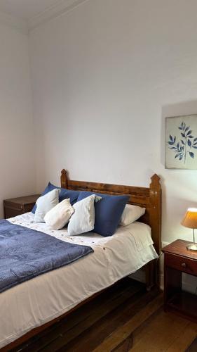 a bed with blue and white pillows on it at BbCasita Yellow in Valparaíso