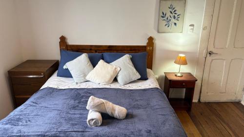 a bedroom with a blue bed with two slippers on it at BbCasita Yellow in Valparaíso