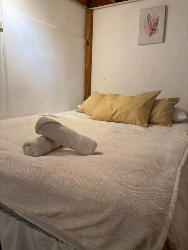 a white bed with a towel on top of it at BbCasita Yellow in Valparaíso