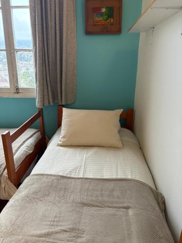 a small bed in a room with a window at BbCasita Yellow in Valparaíso