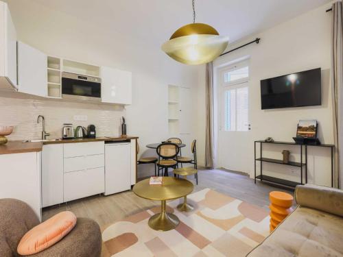 a living room with a couch and a table and a kitchen at Cosy Apartment - 1BR 2P- Saint-Cloud in Saint-Cloud