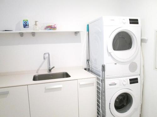 a kitchen with a washing machine and a sink at Peace of Mind - Las Brisas in Koolbaai