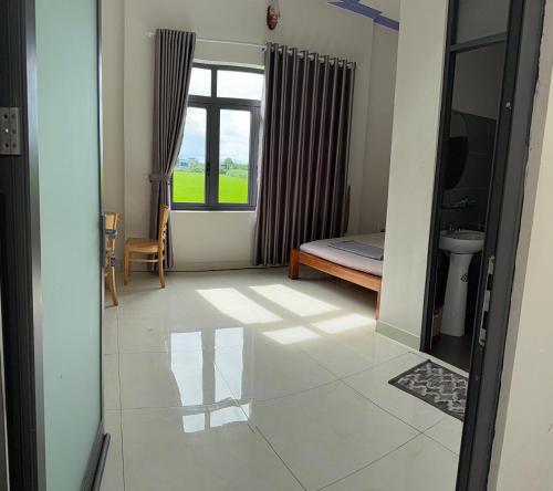 a room with a view of a bedroom with a window at Hương Tràm Homestay in Hồ Ðá