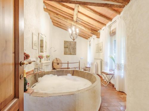 a large bath tub in a room with a wooden ceiling at Villa in Lucca with Private Pool in San Macario In Piano