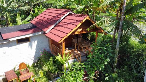 a small house with a red roof at Bintang Homestay in Tetebatu