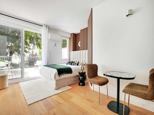 a bedroom with a bed and a table and chairs at Cozy Studio with Balcony 2 Guests Paris 16th in Paris