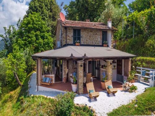 a small stone house with a porch and chairs at Villa in Pescia with Tuscan Wine Views in Pescia