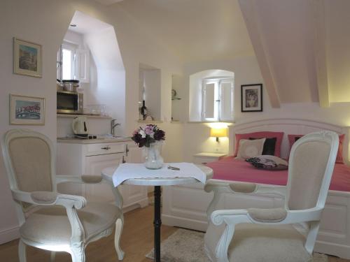 1 dormitorio con 1 cama, mesa y sillas en Studio Apartments Sonatina, en Dubrovnik
