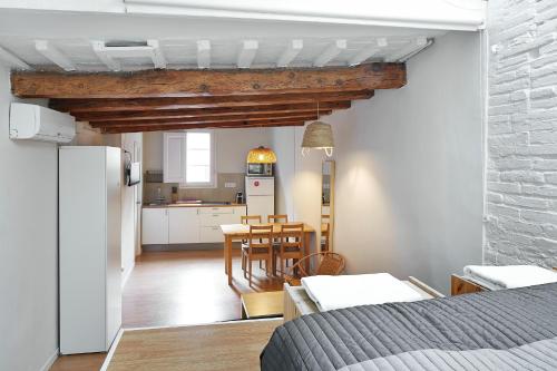 une cuisine et une salle à manger avec une table et un réfrigérateur dans l'établissement Barcelona Mercaders Apartments, à Barcelone