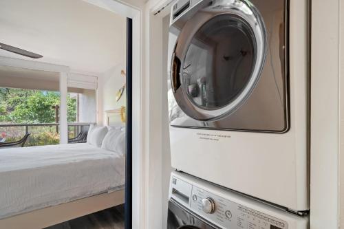 a washer and dryer in a room with a bed at Renovated Condo - 3 Min Walk to Toes in the Sand! in Wailea