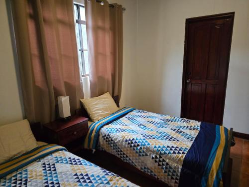 a bedroom with two beds and a window at Hostal Casa San Mateo in León