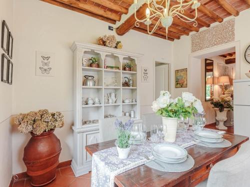 a dining room with a table and a chandelier at Farmhouse near Lucca with Tuscan Views in Pieve di compito