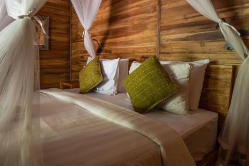 a bedroom with a bed with curtains and pillows at Sweet Orange Pondok in Ubud