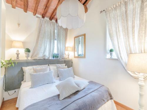 a bedroom with a bed with white sheets and pillows at Farmhouse near Lucca with Tuscan Views in Pieve di compito