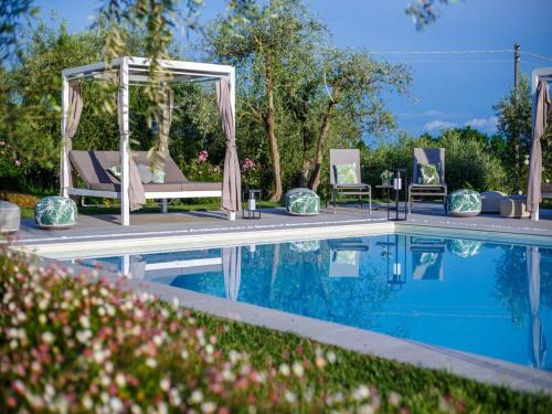 a pool with two chairs and a gazebo next to at 10 Bedrooms Villa in Lucca with pool in Montecarlo