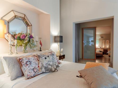 a bedroom with a bed with a mirror and flowers on it at 10 Bedrooms Villa in Lucca with pool in Montecarlo