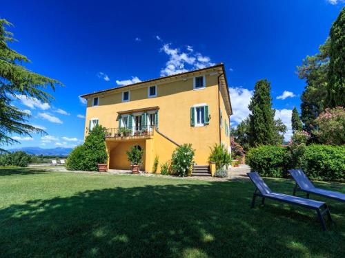 a yellow house with a bench in the yard at 10 Bedrooms Villa in Lucca with pool in Montecarlo
