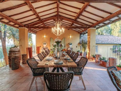 an outdoor dining room with a large wooden table and chairs at 10 Bedrooms Villa in Lucca with pool in Montecarlo