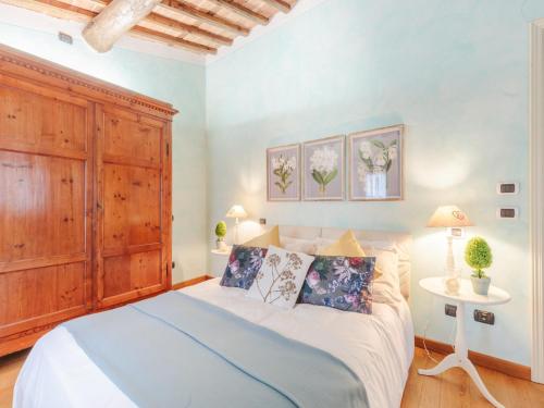 a bedroom with a large bed and a wooden cabinet at Farmhouse in Tuscany with Pool and Scenic Views in Chiatri