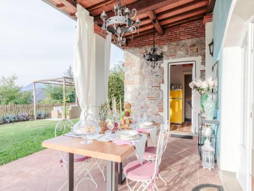 a table with pink chairs on a patio at Farmhouse in Tuscany with Pool and Scenic Views in Chiatri