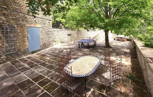 a patio with a table and chairs and a tree at Awesome Home In Goult With Wifi in Goult