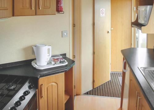 a kitchen with a stove and a counter top at The Chase Holiday Park in Addlethorpe