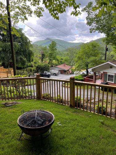a fire pit in the yard next to a fence at Mountain Aire Cottages, Inn, & Glamping in Clayton