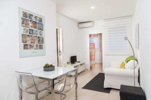 uma sala de estar branca com uma mesa e cadeiras em Apartament Conde Güell em Barcelona