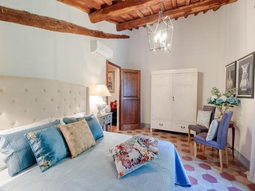 a bedroom with a large bed with blue pillows at 10 Bedrooms Villa in Lucca with pool in Montecarlo