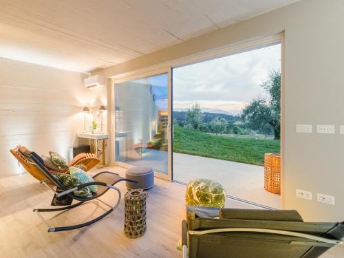 a living room with chairs and a large window at 10 Bedrooms Villa in Lucca with pool in Montecarlo