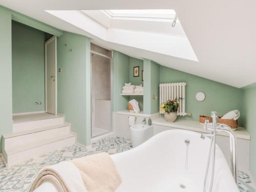 baño con bañera blanca y paredes verdes en Villa in Tuscany with Private Pool and Charm, en Bientina