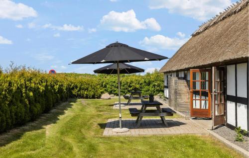a picnic table with an umbrella next to a building at Stunning Home In Otterup With Kitchen in Otterup