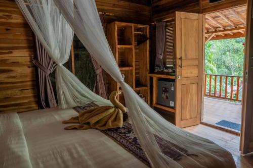 a bedroom with a bed with a mosquito net at Sweet Orange Pondok in Ubud