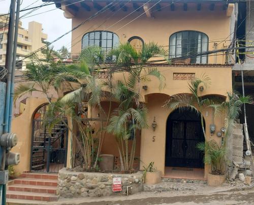 a house with palm trees in front of it at Botanical Studios Sayulita in Sayulita
