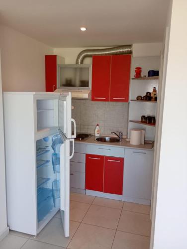 Una pequeña cocina con gabinetes rojos y lavavajillas. en Maria Residence 12A Costinesti, en Mangalia