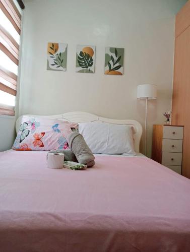 a bedroom with a bed with a pink bedspread at Khyzer's Place in Quezon City