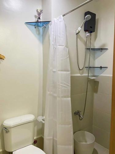 a bathroom with a shower with a toilet and a shower curtain at Khyzer's Place in Quezon City
