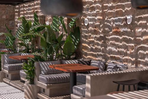 a patio with a table and couches and plants at Noir Mykonos in Mýkonos City