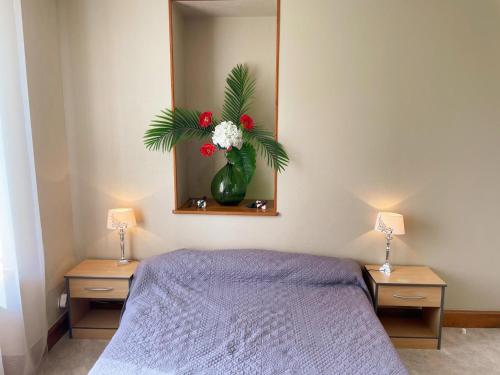 a bedroom with a bed and a vase with flowers at Maison familiale confortable avec grand jardin, proche des châteaux de la Loire et zoo de Beauval - FR-1-491-433 in Soings-en-Sologne