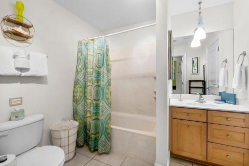 a bathroom with a toilet sink and a shower curtain at 30A - Cassine Station by Panhandle Getaways in Santa Rosa Beach