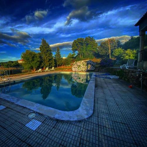 a swimming pool in a yard with a cloudy sky at Rustic Terrace2 Bedrooms Farm House in Mesquitela