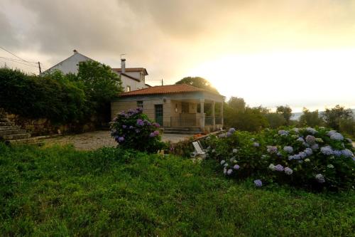 a small house with flowers in front of it at Rustic Terrace2 Bedrooms Farm House in Mesquitela
