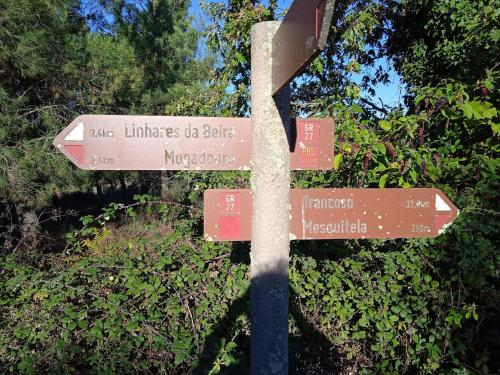 a street sign with arrows pointing to different places at Rustic Terrace2 Bedrooms Farm House in Mesquitela